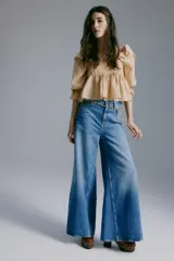 Blusa de viscosa con estampado floreado en tonos tostados y blancos, escote cuadrado, mangas largas abullonadas con puños elásticos y volados, y detalle fruncido bajo el busto.