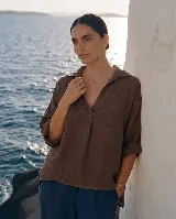 Blusa de lino color blanco, con cuello camisero y escote en V profundo, mangas 3/4 y corte holgado.