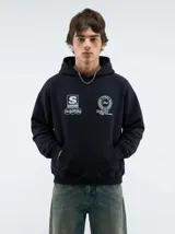 Hoodie negro con capucha, diseño estampado en la espalda con el logo de la marca dentro de un círculo de laureles y texto en la parte posterior de la capucha.