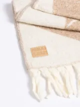 Bufanda de lana con diseño geométrico en tonos gris y marrón, con flecos en los extremos y etiqueta de marca cosida.