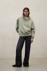 Hoodie de felpa de algodón reciclado, color verde claro, de corte relajado, con capucha con cordón ajustable, hombros caídos, puños y bajo acanalados.