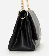 Cartera shoulder grande de Satinato color beige, confeccionada en PU con textura símil cuero. Cuenta con solapa frontal con cierre de botón magnético, detalles metálicos en tono dorado claro y asa de cadena metálica.
