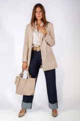 Blazer color beige con diseño bordado tono sobre tono en mangas y parte inferior. Presenta corte recto, solapas clásicas, cierre frontal con un botón y bolsillos laterales con solapa.