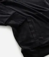 Campera deportiva de Ashua confeccionada en plush negro, con cuello alto, cierre frontal por cremallera y bolsillos laterales.