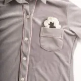 Pijama de dos piezas color rosa pálido, confeccionado en terciopelo. La camisa es de manga larga con botones frontales y bolsillo en el pecho. El pantalón es de corte recto con cintura elástica.