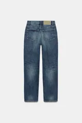 Jeans de tiro medio con corte straight, color azul con efecto lavado y roturas sutiles, cinco bolsillos y cierre frontal con cremallera y botón metálico.