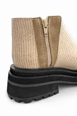 Botín color beige con textura acanalada, paneles laterales de gamuza color camel y suela track color negro.