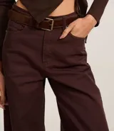 Pantalón wide leg color crudo confeccionado en sarga con pespuntes contrastantes, cintura alta con trabillas, cierre por botón y cremallera, bolsillos delanteros y traseros.