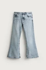 Jeans flare fit de tiro medio, confeccionados en denim de algodón color azul con efecto deslavado. Diseño ajustado en la parte superior y abierto en campana desde la rodilla, con cinco bolsillos y cierre frontal con cremallera y botón.