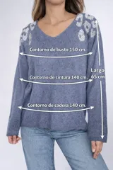 Buzo de punto oversize color beige, con escote en V y detalles de piedras plateadas en los hombros que forman un diseño tipo print.