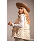 Chaleco beige capitoneado con cierre frontal y cuello de pana marrón.