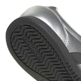 Championes urbanos Adidas modelo Barreda Lo, color plateado metalizado con las icónicas tres tiras en color negro y suela oscura. Presentan un diseño de perfil bajo con perforaciones en la puntera y cordones al tono.