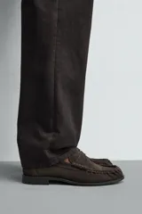 Mocasín de vestir confeccionado en piel con acabado de serraje, presenta un diseño clásico con detalle de antifaz en el empeine y suela a contraste con un ligero tacón.