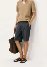 Bermuda de sarga modelo chino, color rosado, con cierre de botón y cremallera, bolsillos laterales y corte recto.