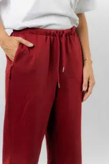 Pantalón jogger de calce relajado color bordó intenso, con cintura elastizada y lazo regulable. Cuenta con bolsillos laterales con cierre invisible y silueta recta levemente afinada.