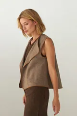 Chaleco color beige con textura tipo espiga, corte holgado y solapa cruzada.