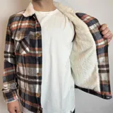 Chaqueta de jean negra con cuello de corderito blanco, cierre frontal con botones metálicos y bolsillos frontales con solapa.