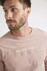 Remera de manga larga color rosado, con cuello redondo y estampado frontal con el nombre de la marca Brooksfield.