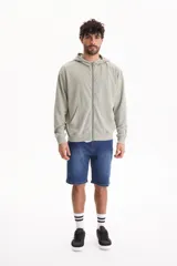 Campera con capucha y cierre frontal, color beige con efecto lavado stone wash, bolsillos tipo canguro y corte oversize.