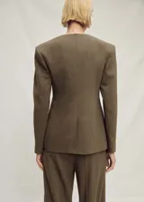 Blazer de corte oversize confeccionado en tejido mezcla de lino, con cuello de pico, cierre frontal y mangas largas con efecto globo. Presenta dos bolsillos de ribete laterales y abertura posterior en el bajo.