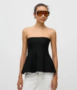 Blusa negra sin breteles, confeccionada en tejido de punto, con diseño ajustado en el busto y detalle de peplum en el ruedo que aporta volumen y movimiento.
