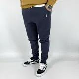 Pantalón de jogging azul marino con puños ajustados y logo bordado en dorado.