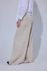 Pantalón de tiro medio y piernas anchas, confeccionado en mezcla de lino y algodón, con bolsillos delanteros y traseros con detalles de costuras pespunteadas a contratono.