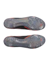Championes de fútbol Under Armour modelo UA Shadow Elite 3 FG, diseñados para velocidad y agilidad en superficies de terreno firme. Presentan una parte superior textil UA IntelliKnit en color negro con degradado naranja y detalles multicolores, con el logotipo de la marca en el lateral y suela exterior de fibra de carbono con tapones.