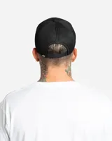 Gorro trucker negro con diseño clásico de paneles frontales de tela y parte trasera de red, con visera curva y pequeño logo estampado en el lateral.