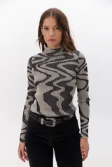 Polera de tejido de punto con diseño vanizado que combina tonos tierra y crema en un patrón abstracto de líneas onduladas. Presenta cuello alto, mangas largas y un ajuste entallado al cuerpo.