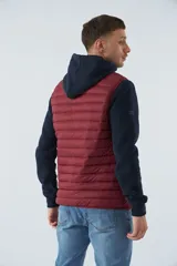 Chaleco puffer verde oliva con cierre frontal y bolsillos laterales con cierre. Interior forrado en color naranja.