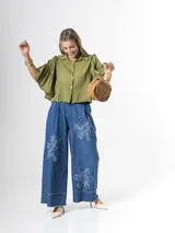 Pantalón wide leg de denim azul, con cintura elástica y apliques de flores grandes en tela vaquera en las piernas.