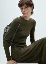 Vestido midi de punto entallado, con cuello redondo y manga larga. Presenta un diseño ajustado al cuerpo con detalle de frunces laterales en la cintura.