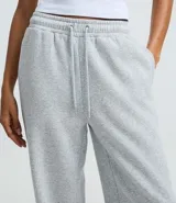 Pantalón de corte recto confeccionado en algodón con felpa, de color marrón. Presenta cintura elástica con cordón ajustable y diseño holgado.
