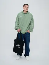 Campera rompevientos Umbro modelo Venti, de color negro con líneas blancas en las mangas y hombros, capucha con cordón de ajuste y cierre frontal completo. Cuenta con el logo de la marca bordado en el pecho.