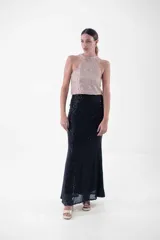 Vestido largo con cuello halter enteramente cubierto de lentejuelas, que combina un cuerpo superior en tono rosado y una falda larga en color negro.