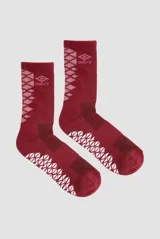 Medias deportivas Umbro de media caña, color bordó con detalles geométricos en rosa y blanco. Presentan diseño ergonómico con refuerzos en zonas clave y logo de la marca en la parte superior.