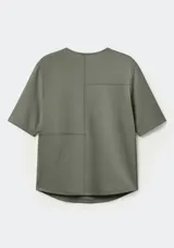 Blusa de manga corta color verde militar, con cuello redondo y diseño de paneles con costuras visibles.