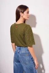 Remera de algodón peinado color negro, con mangas cortas de broderie con diseño calado y terminación festoneada. Presenta un corte oversize y cuello redondo.