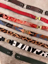 Cinto de cuero marrón con hebilla metálica plateada y doble pasador.