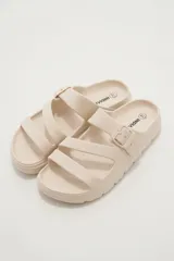 Sandalias de goma color negro con diseño de tres tiras cruzadas y hebilla lateral ajustable.