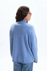 Polera de punto en color celeste, de corte holgado, cuello alto y manga larga con terminaciones simples.
