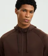 Saco deportivo con capucha ajustable y cierre frontal por cremallera. Confeccionado en tejido tech fleece liviano y transpirable, cuenta con bolsillos laterales con cierre.