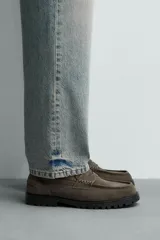 Mocasín de vestir en piel con acabado serraje color verde militar, con detalle de antifaz en el empeine y suela track dentada.