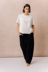 Pantalón negro de silueta amplia y pierna recta, con cintura elástica, cordón regulable y bolsillos laterales.