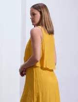 Vestido largo blanco de crepe con escote redondo y detalle de crochet en los hombros. Tiene corte en la cintura con punto smock.