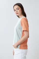 Remera de manga corta con diseño color block, combinando paneles en color blanco, naranja y verde agua.