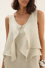 Musculosa blanca de lino con volados en el frente.