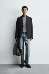 Blazer de corte relajado confeccionado en lino italiano, con cuello de solapas de muesca, cierre frontal de un botón, bolsillo de vivo en el pecho y bolsillos de plastrón en la cadera.