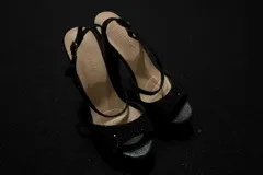 Sandalias de fiesta color negro con plataforma y taco alto cuadrado. Presentan tiras cruzadas en el empeine con acabado brillante y cierre de pulsera con hebilla metálica.